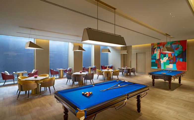 A Seating Area and pool table in a room, ready for a game.